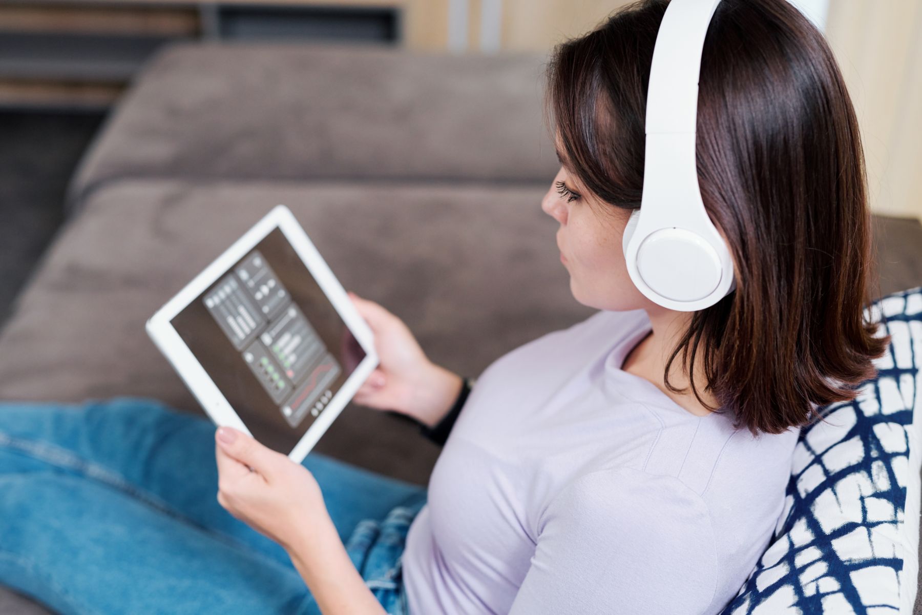 young-woman-in-headphones-looking-at-remote-4ZG96T5.jpg